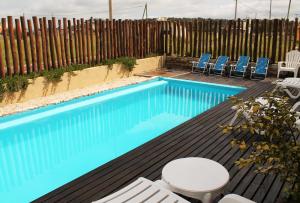 圣克拉拉德尔马尔Akun Hotel的一个带椅子和围栏的游泳池