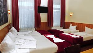 汉堡阿尔坦酒店的配有红色窗帘的酒店客房的两张床