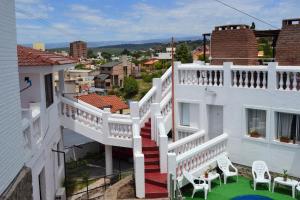 维拉卡洛斯帕兹Atenea的阳台设有红色和白色的楼梯和椅子。