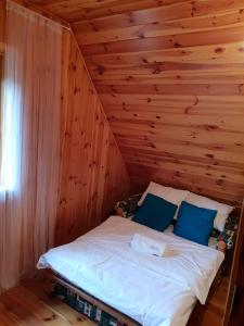 Klusek BiałyLAGO BLANCO的卧室配有木墙内的一张床