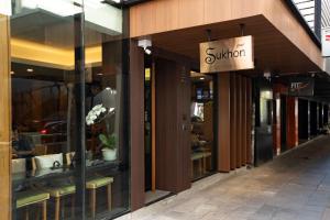 曼谷Sukhon Hotel - SHA Plus的书店前方有读太阳的标牌