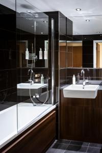 布伦特福德Aparthotel Adagio London Brentford的一间带两个水槽和玻璃淋浴间的浴室