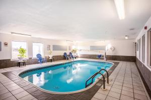 盖尔斯堡American inn and suites的游泳池位于酒店客房内,配有桌椅