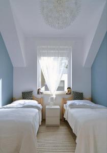卢克钦Chill&Sun的配有窗户和吊灯的客房内的两张床