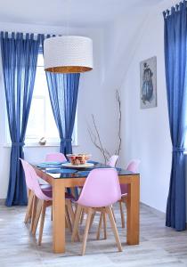卢克钦Chill&Sun的一间带桌子和粉红色椅子的用餐室