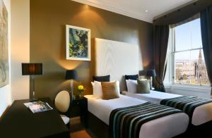 爱丁堡爱丁堡辉盛阁国际公寓的酒店客房设有两张床和窗户。
