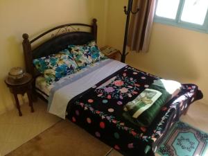 泰夫劳特Azur Tafraout的一间卧室配有一张带花卉图案的毯子的床
