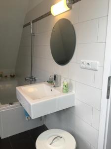 慕尼黑Helle und ruhige Dachgeschosswohnung的一间带水槽、卫生间和镜子的浴室