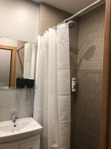 维尔纽斯K&P Apartment的浴室设有白色的淋浴帘和水槽