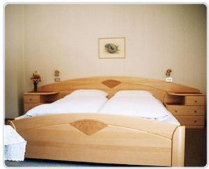 塞尔瓦迪加尔代纳山谷加尔尼马特尔霍夫旅馆的一间卧室配有木床和梳妆台