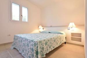 托尔托利VILLA MILVIO con accesso privato in spiaggia的一间卧室配有一张带蓝色毯子的床和两个窗户。