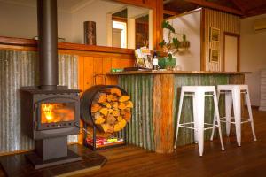 布洛克Peppercorn Cabin的厨房配有木炉和2张凳子