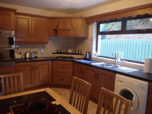 CoalislandTorrent Cottage的厨房配有木制橱柜、水槽和洗碗机。