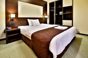 图兹拉金星精品酒店的一间卧室配有一张大床和一部电话
