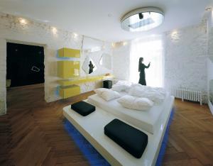 梅拉诺欧若拉酒店的一间设有两张床的房间和一个站在窗户上的人
