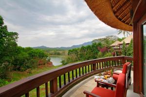 NegaraTaman Wana Resort Palasari的河景阳台配有桌椅