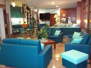加利波利利瓦贝拉酒店的一间带蓝色沙发的客厅和一间厨房