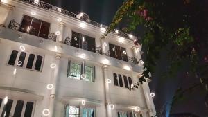 加尔各答格鲁吉亚酒店的白色的建筑,晚上有灯