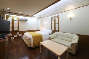 冈山Hotel Fine Garden Okayama II的酒店客房,配有床和沙发