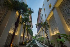 金巴兰巴厘岛百丽宫度假酒店的两栋建筑之间一条棕榈树街道