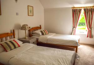 尼纳The Waterside Cottages的一间卧室设有两张床和窗户。