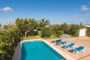休达德亚Villa Sa Canova by Mauter Villas的一个带2把蓝色椅子的游泳池和一个泳池景