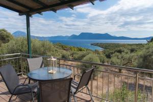 KatomérionVilla Iliogioma with private pool and sea view的阳台配有桌椅,享有水景。