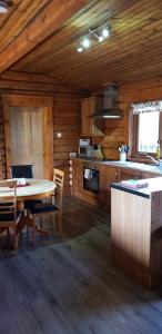 威廉堡Glenmhor Log Cabin的小屋内的厨房配有桌椅