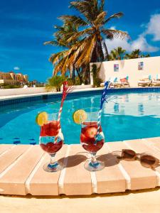 棕榈滩卡里布阿鲁巴精品酒店的游泳池畔的桌子上放着两杯饮料