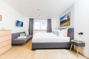 绍滕斯Easy Living Apartment Ötztal的一间卧室配有一张床和一张沙发
