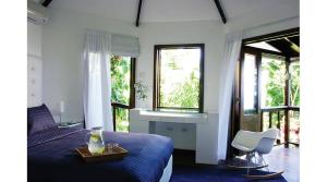 安东尼奥港吉加姆酒店的一间卧室配有一张床、一把椅子和窗户。