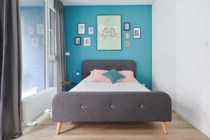 波兹南Mint Apartment的一间卧室配有一张蓝色墙壁的床