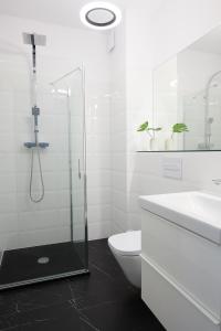 波兹南Mint Apartment的带淋浴、卫生间和盥洗盆的浴室