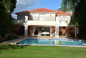 璜多里奥Metro Country Club的一座大房子,前面设有一个游泳池