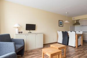霍勒姆Appartement De Vrijbuiter, Resort Amelander Kaap的带沙发和电视的客厅