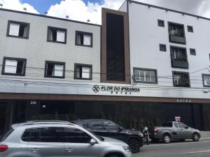 圣保罗Hotel Flor do Ipiranga (Adult Only)的两辆汽车停在大楼前