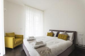 米兰Design & New Center Apartments的一间卧室配有一张床和一张黄色椅子
