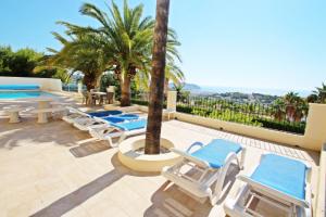 特乌拉达Casa del Campo - sea view villa with private pool in Moraira的一个带躺椅的庭院和一个游泳池