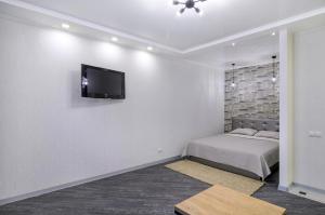 苏梅Greatest Luxury Apart-Hotel的一间卧室配有一张床,墙上配有电视