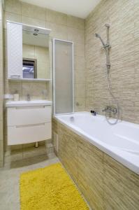 苏梅Greatest Luxury Apart-Hotel的带浴缸、水槽和镜子的浴室