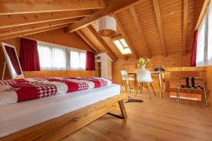 格施泰格维勒Chalet Wäschhüsli near Interlaken, Grindelwald and Lauterbrunnen的卧室配有一张床和一张桌子及椅子