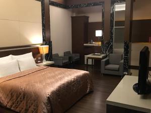 台南京华商务汽车旅馆的配有一张床和一把椅子的酒店客房