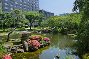 东京高轮花香路旅馆的花园,花园内设有一个种满鲜花的池塘和一个鸟浴池