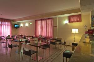 佛罗伦萨Mio Hotel Firenze的一间带桌椅和电视的用餐室