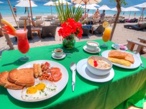 吉利阿尔吉利阿尔简易别墅酒店的一张桌子,上面有一盘早餐食品在沙滩上