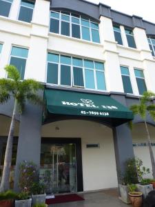 莎阿南梳邦@138酒店的一座有绿色遮阳篷和棕榈树的建筑