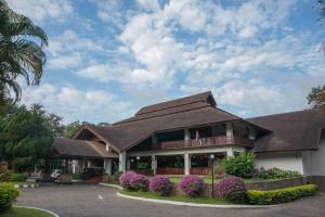 湄宏颂帝国湄宏顺度假酒店的一座棕色屋顶和紫色花卉的建筑
