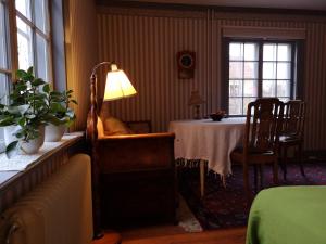 纳卡Stockholm B&B Cottage的配有桌子、椅子和灯的房间