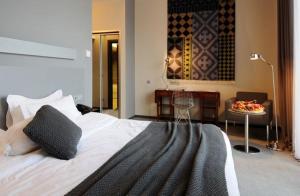 西格纳吉卡巴都尼精品酒店的一间卧室配有一张大床、一张桌子和一张桌子