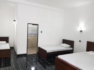 锡吉里亚Green House Resort的带两张床和镜子的客房